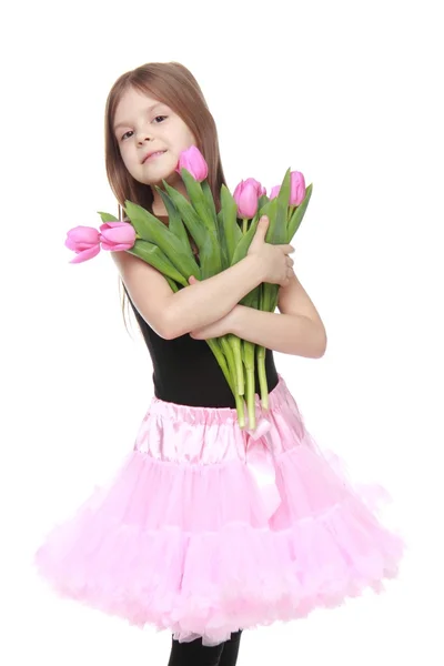Emocional niña en un tutú sosteniendo un hermoso ramo de tulipanes —  Fotos de Stock