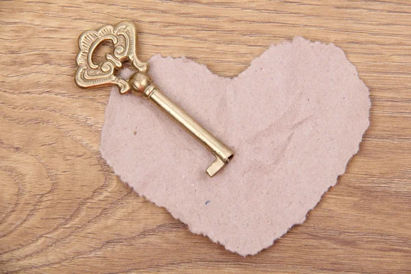Antika ahşap zemin üzerine süs ve kağıt kalp anahtarla — Stok fotoğraf