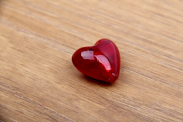 Corazón rojo de vidrio aislado sobre fondo de madera — Foto de Stock