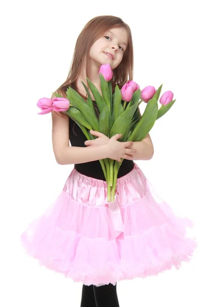 Emoční holčička v tutu drží krásné kytice tulipánů — Stock fotografie
