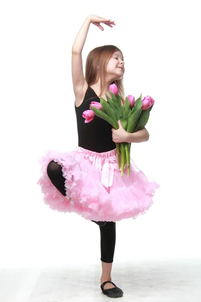 Pequeña bailarina encantadora con el pelo largo sosteniendo un hermoso ramo de tulipanes — Foto de Stock