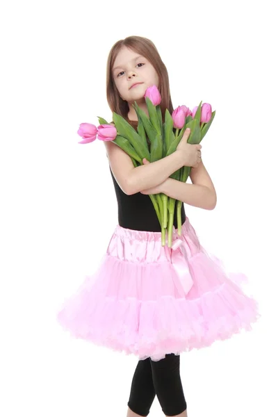 Charmante kleine danser met lange haren die een mooi boeket van tulpen — Stockfoto