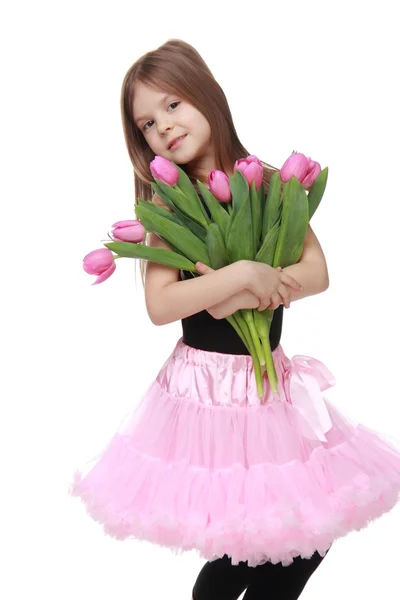 Emotional little ballerina in a tutu holding a big bouquet of tulips — Stock Photo, Image