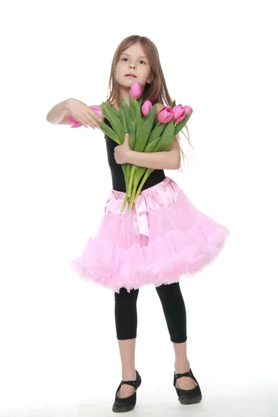 Beautiful little ballerina in a tutu holding a big bouquet of tulips — Stock Photo, Image