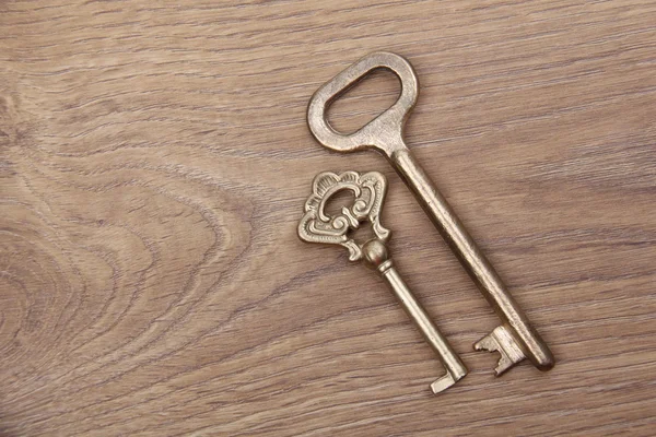 Dos llaves vintage con adorno sobre fondo de madera — Foto de Stock