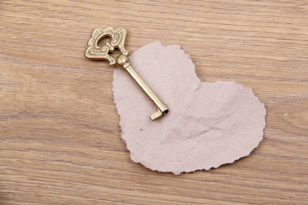 Antika ahşap zemin üzerine süs ve kağıt kalp anahtarla — Stok fotoğraf
