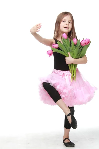 Beautiful little ballerina in a tutu holding a big bouquet of tulips — Stock Photo, Image