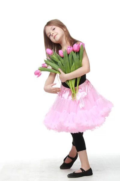 Gelukkig weinig danser met lange haren die een mooi boeket van tulpen — Stockfoto