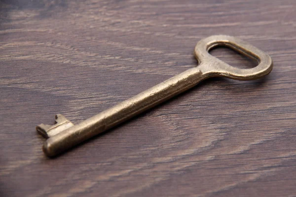 Llave antigua aislada sobre fondo de madera —  Fotos de Stock