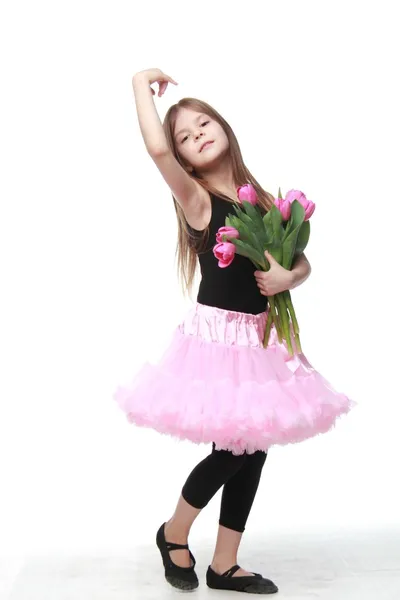 Emocional niña en un tutú sosteniendo un hermoso ramo de tulipanes — Foto de Stock