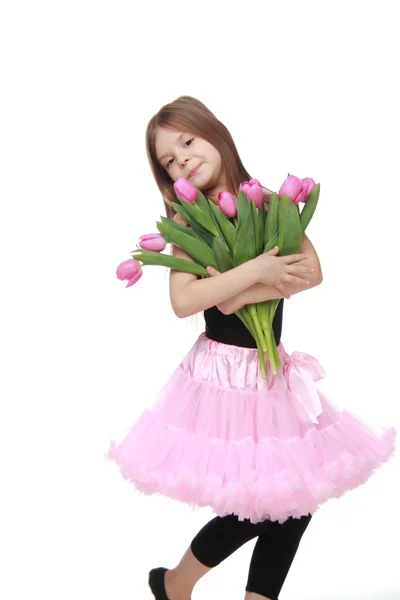 Emocional niña en un tutú sosteniendo un hermoso ramo de tulipanes —  Fotos de Stock