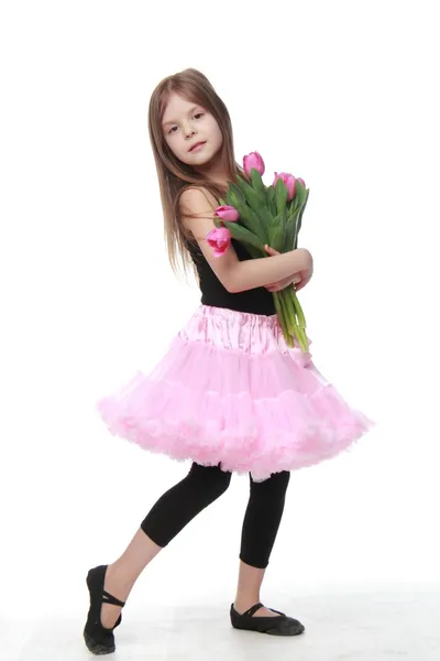 Llittle ballerina in een bedrijf een boeket van tulpen tutu — Stockfoto