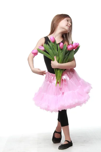 チューリップの美しい花束を保持して長い髪と幸せなリトル ダンサー — ストック写真