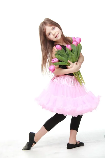 Pequeña bailarina emocional en un tutú sosteniendo un gran ramo de tulipanes — Foto de Stock