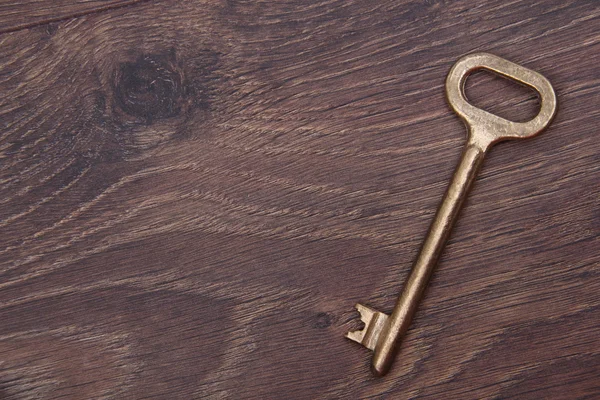 Антикварный ключ на деревянном фоне — стоковое фото