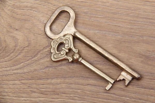 Ahşap zemin üzerinde süsleme ile iki vintage anahtar — Stok fotoğraf