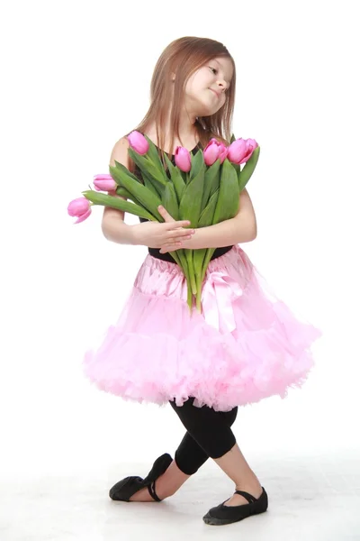 Pretty little dancer with long hair holding a beautiful bouquet of tulips — Stock Photo, Image