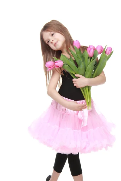 Happy little dancer with long hair holding a beautiful bouquet of tulips — Stock Photo, Image