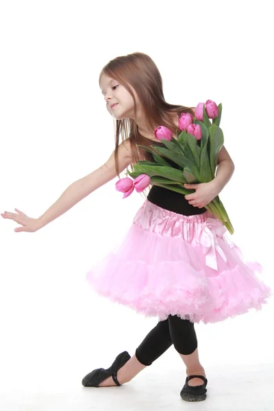 Ładny mały tancerz z długimi włosami, z pięknym bukietem tulipanów — Zdjęcie stockowe