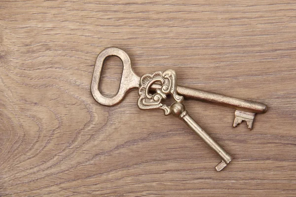Ahşap zemin üzerinde süsleme ile iki eski anahtar — Stok fotoğraf