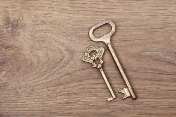 Dva staré klíče na dřevěné pozadí — Stock fotografie