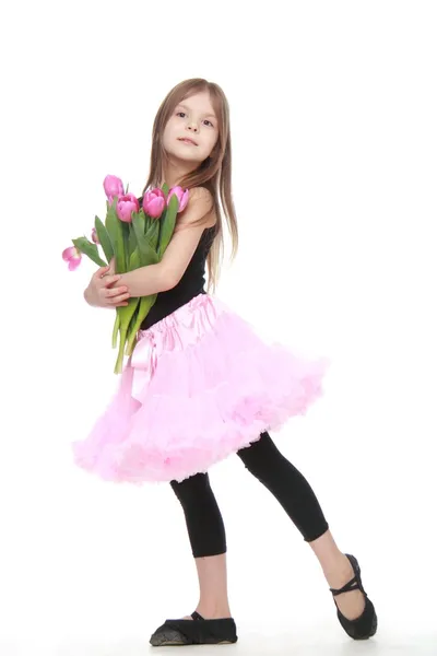 Эмоциональная маленькая балерина в пачке с большим букетом тюльпанов — стоковое фото