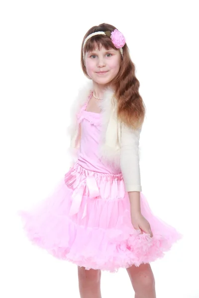 Ukrajinská krásná holčička s dlouhé zdravé vlasy v růžové sukénce na krása a móda — Stock fotografie