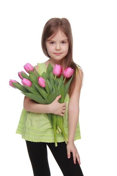 Bild eines schönen Kindes mit einem großen Strauß Tulpen — Stockfoto