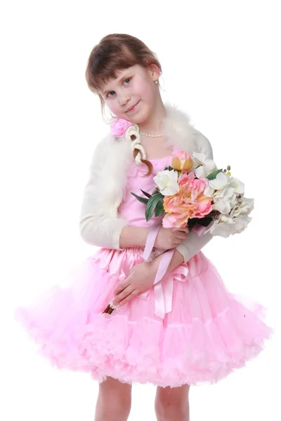 Emocional niña en un hermoso vestido rosa sosteniendo un ramo de tulipanes frescos — Foto de Stock