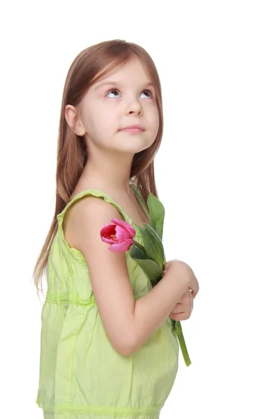 Gelukkig meisje in groen shirt met een tulp — Stockfoto