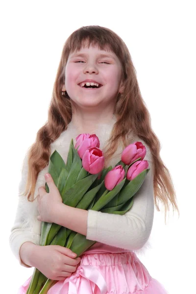 Petite fille émotionnelle dans une belle robe tenant un bouquet de tulipes fraîches — Photo