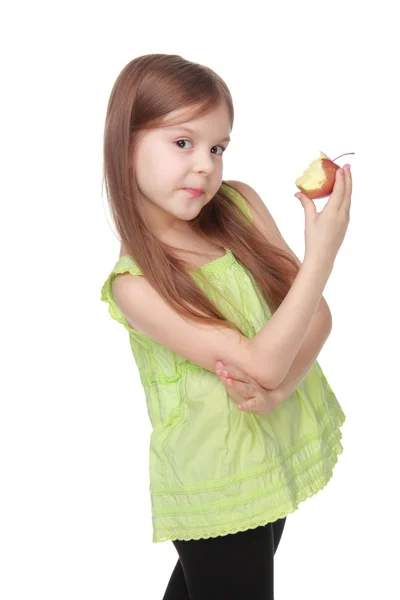 Charming little girl in green shirt eating an apple — Stock Photo, Image