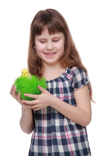 Schönes Mädchen hält einen grünen Korb mit einem kleinen Huhn zu Ostern — Stockfoto