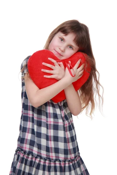 Carino bambina in abito a scacchi in possesso di cuore giocattolo — Foto Stock