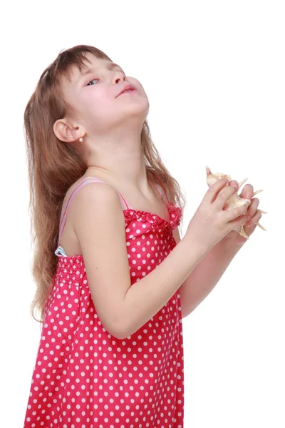 Cheerful little girl holding a seashell — Stock Photo, Image