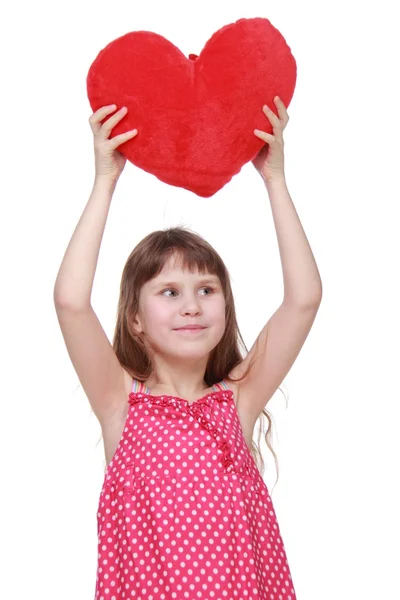 Cute little girl in dress holding toy heart — Stockfoto