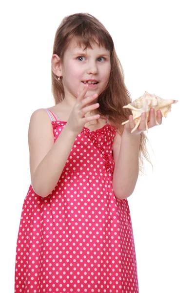 Fröhliches kleines Mädchen mit einer Muschel in der Hand — Stockfoto