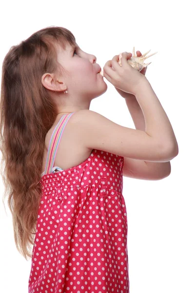 Fröhliches kleines Mädchen mit einer Muschel in der Hand — Stockfoto