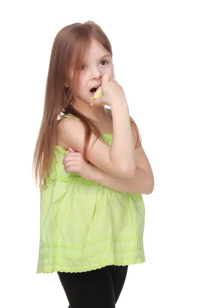 Encantadora niña con camisa verde comiendo una manzana — Foto de Stock