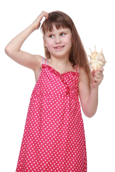 Fröhliches kleines Mädchen mit einer Muschel in der Hand — Stockfoto