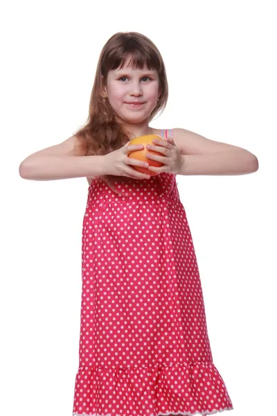 Klein meisje in lichte jurk bedrijf een grapefruit — Stockfoto