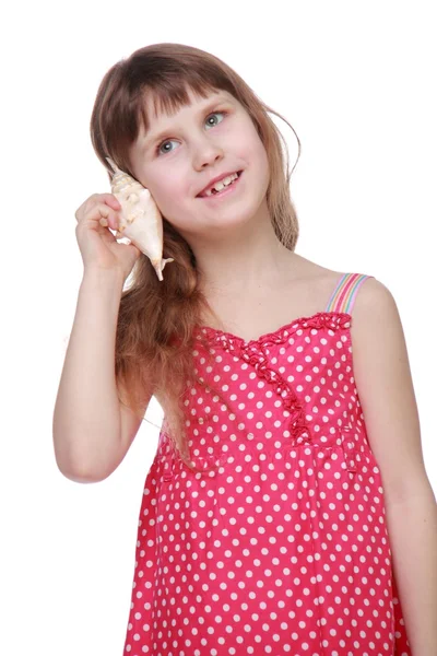 Веселая маленькая девочка с ракушкой в руках — стоковое фото