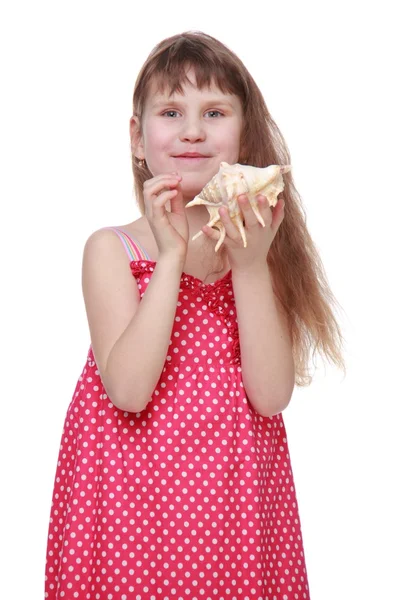 Fröhliches kleines Mädchen mit einer Muschel in der Hand — Stockfoto