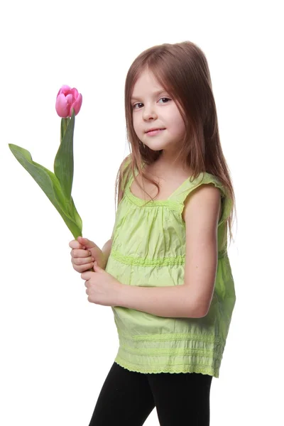 Happy little girl with pink tulip — Stock Photo, Image