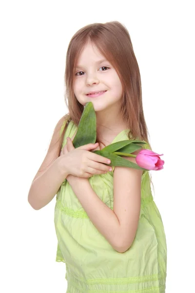 Glückliches kleines Mädchen mit einer Tulpe — Stockfoto