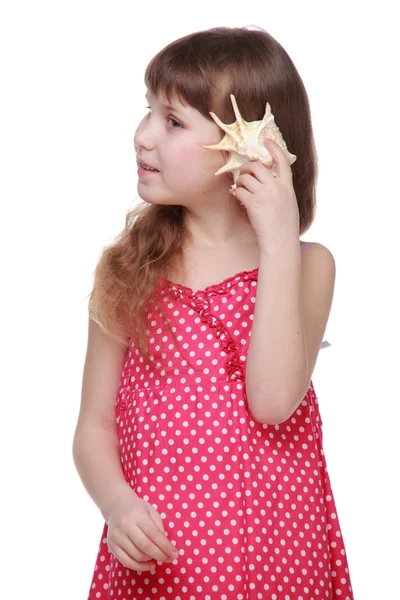 Веселая маленькая девочка с ракушкой в руках — стоковое фото