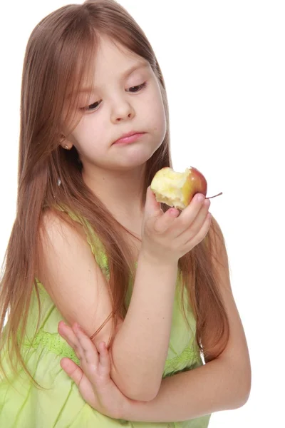 Kleines Mädchen im grünen Hemd isst einen Apfel — Stockfoto