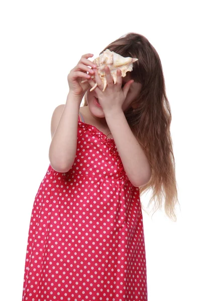 Fröhliches kleines Mädchen mit einer Muschel in der Hand — Stockfoto