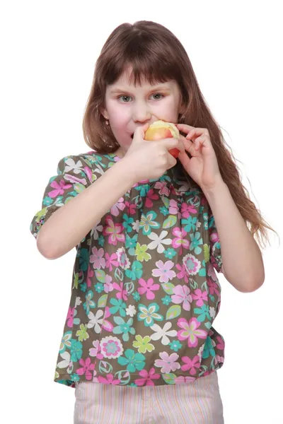 Kislány a színes ruhák eszik almát — Stock Fotó