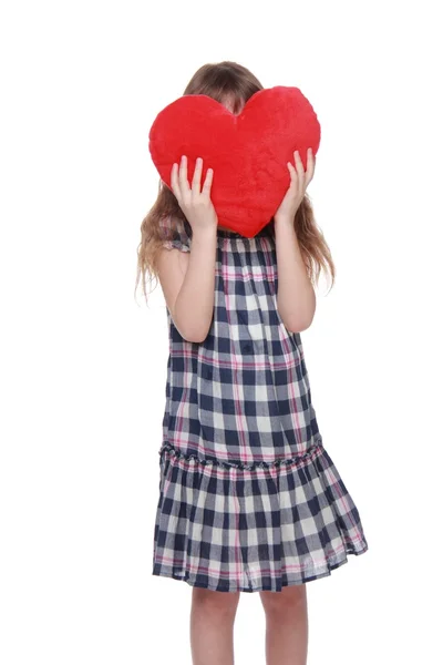 Schattig klein meisje in geruite jurk met speelgoed hart — Stockfoto